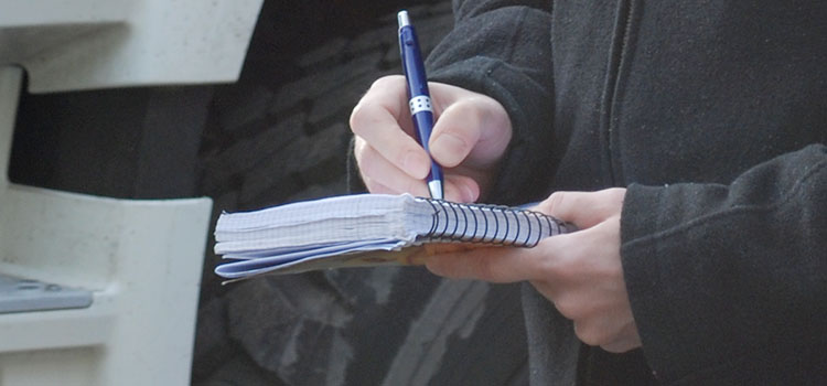 Tendenziös - vom Umgang mit schwierigen Journalisten - Journalist schreibt mit Kugelschreiber auf Block